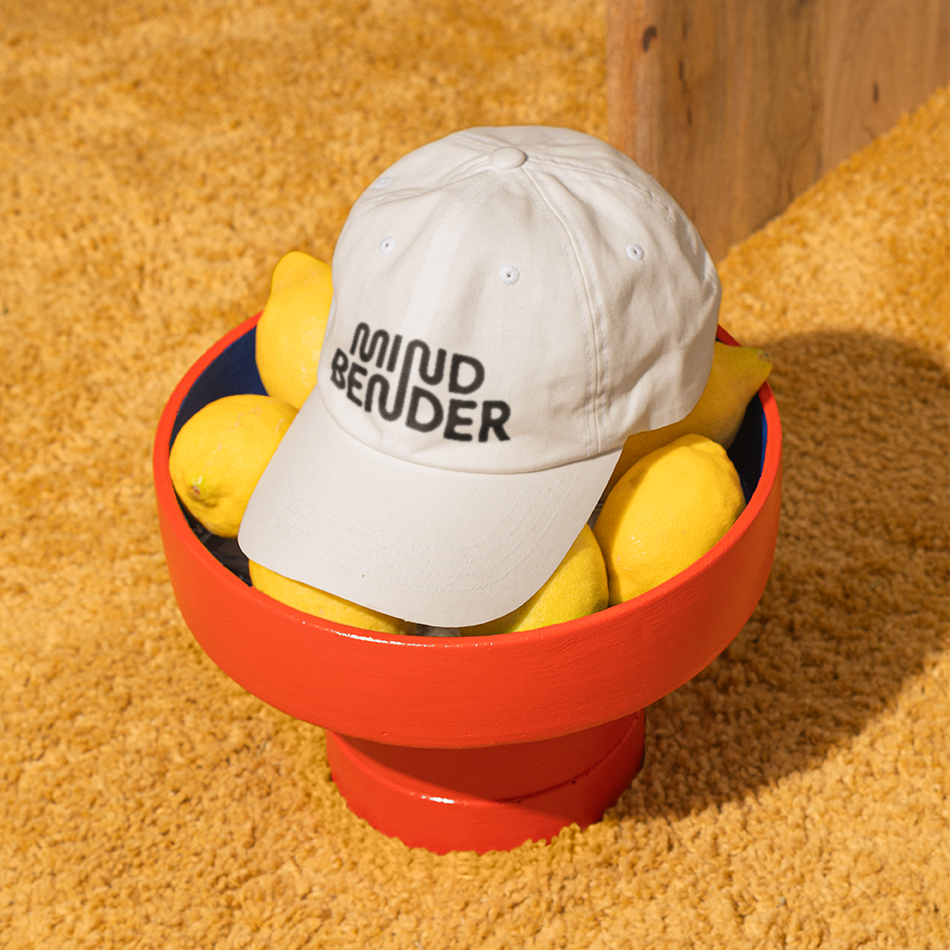 Emblem design for Madame FC depicting an M monogram in a circle with the words "Madame FC EST. 2003" inside on top of a background image of a soccer stadium.